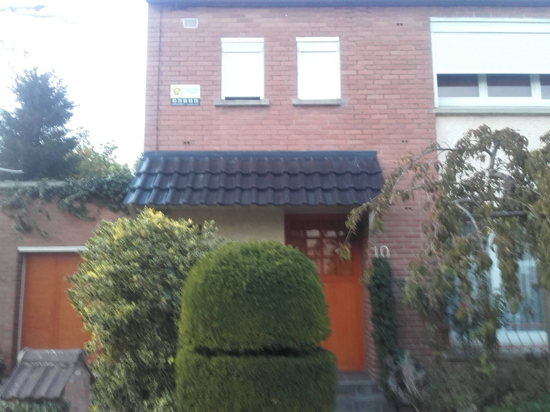 Perron couvert de tuiles qui protège l'entrée d'une maison