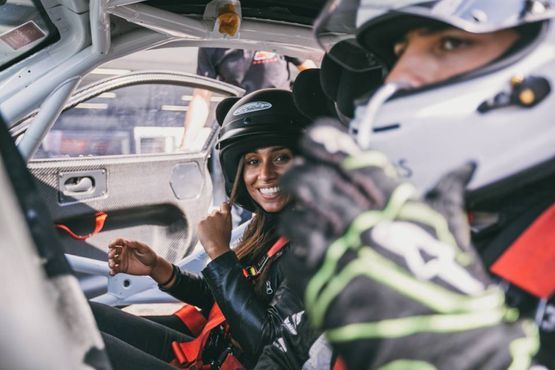 zwei Rennfahrer mit Helmen in einem Fahrzeug