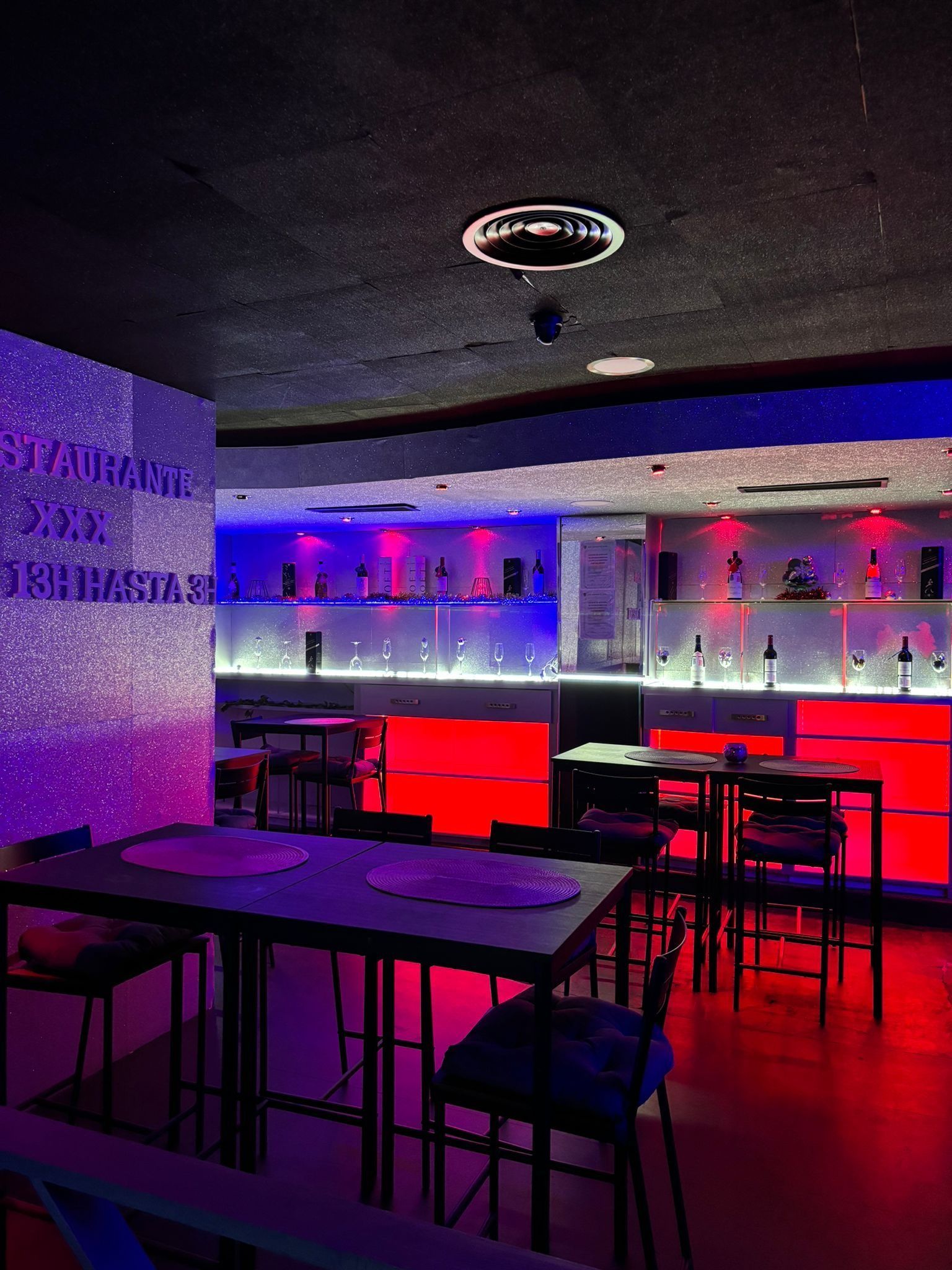 Un restaurante con mesas y sillas y un bar al fondo.