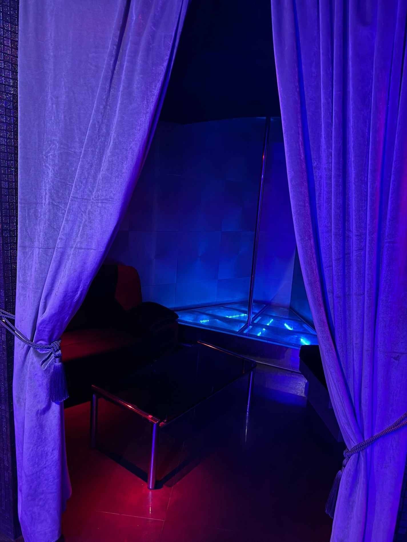 Una habitación con cortinas moradas y un poste en el medio.