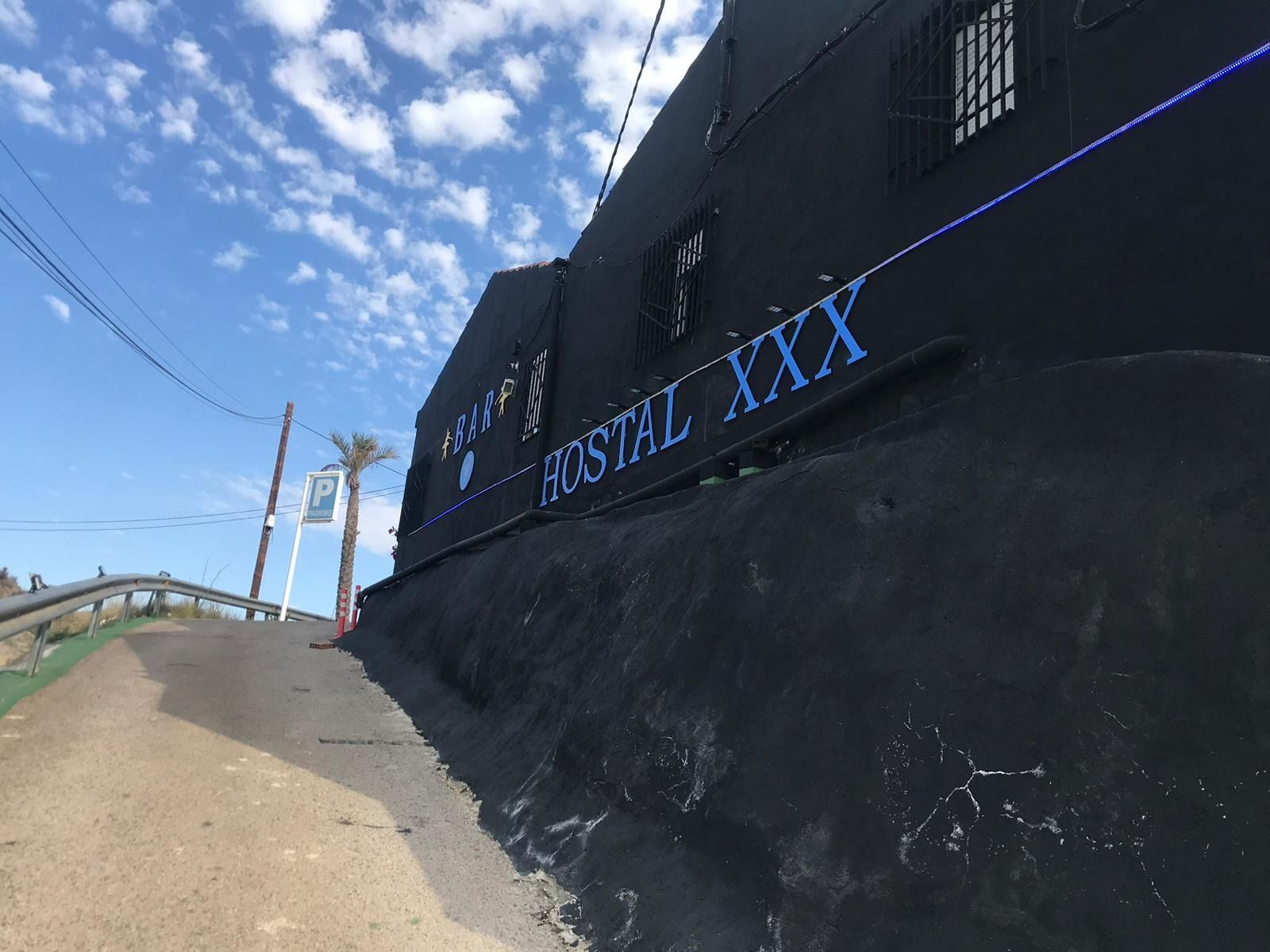 Un edificio negro con un cartel que dice hostal xxx