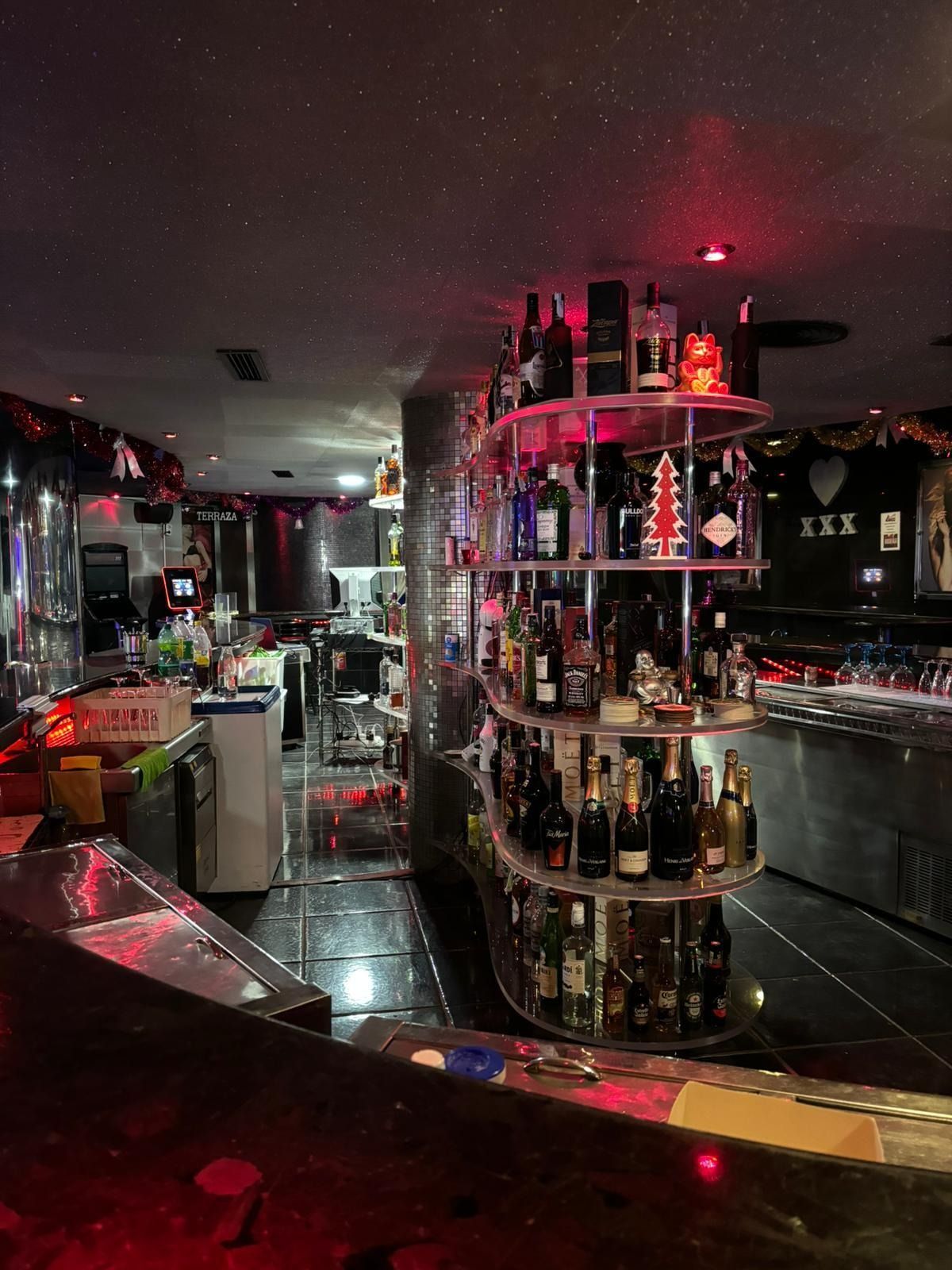 Un bar con muchas botellas de alcohol en los estantes.