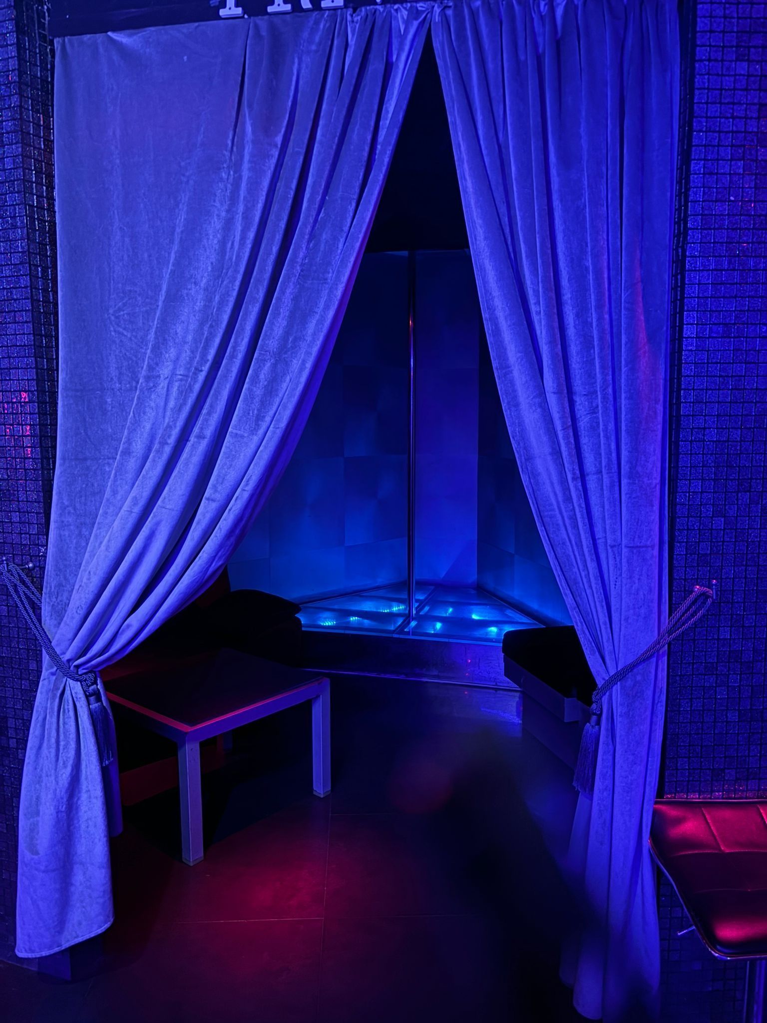 Una habitación con cortinas azules y un poste al fondo.