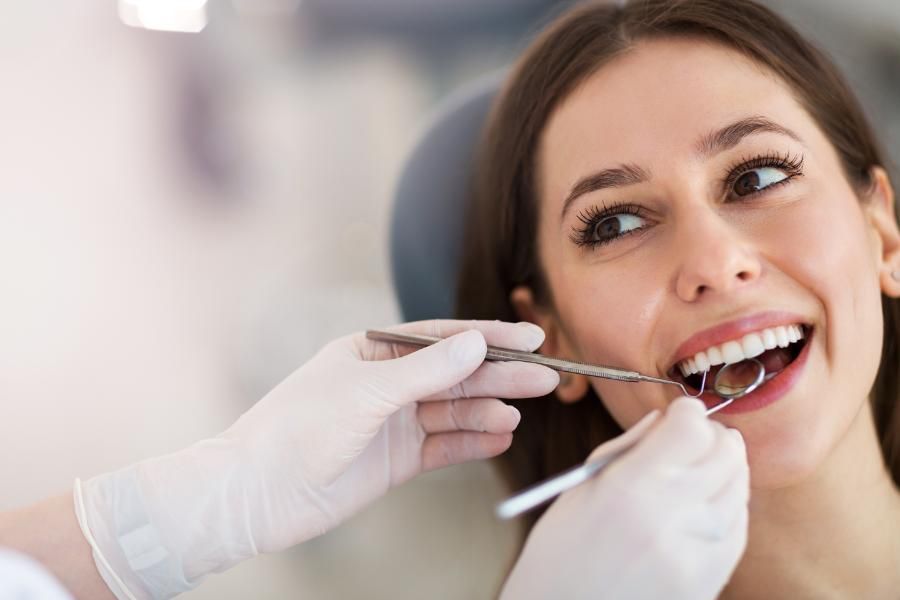 Une femme fait examiner ses dents par un dentiste.