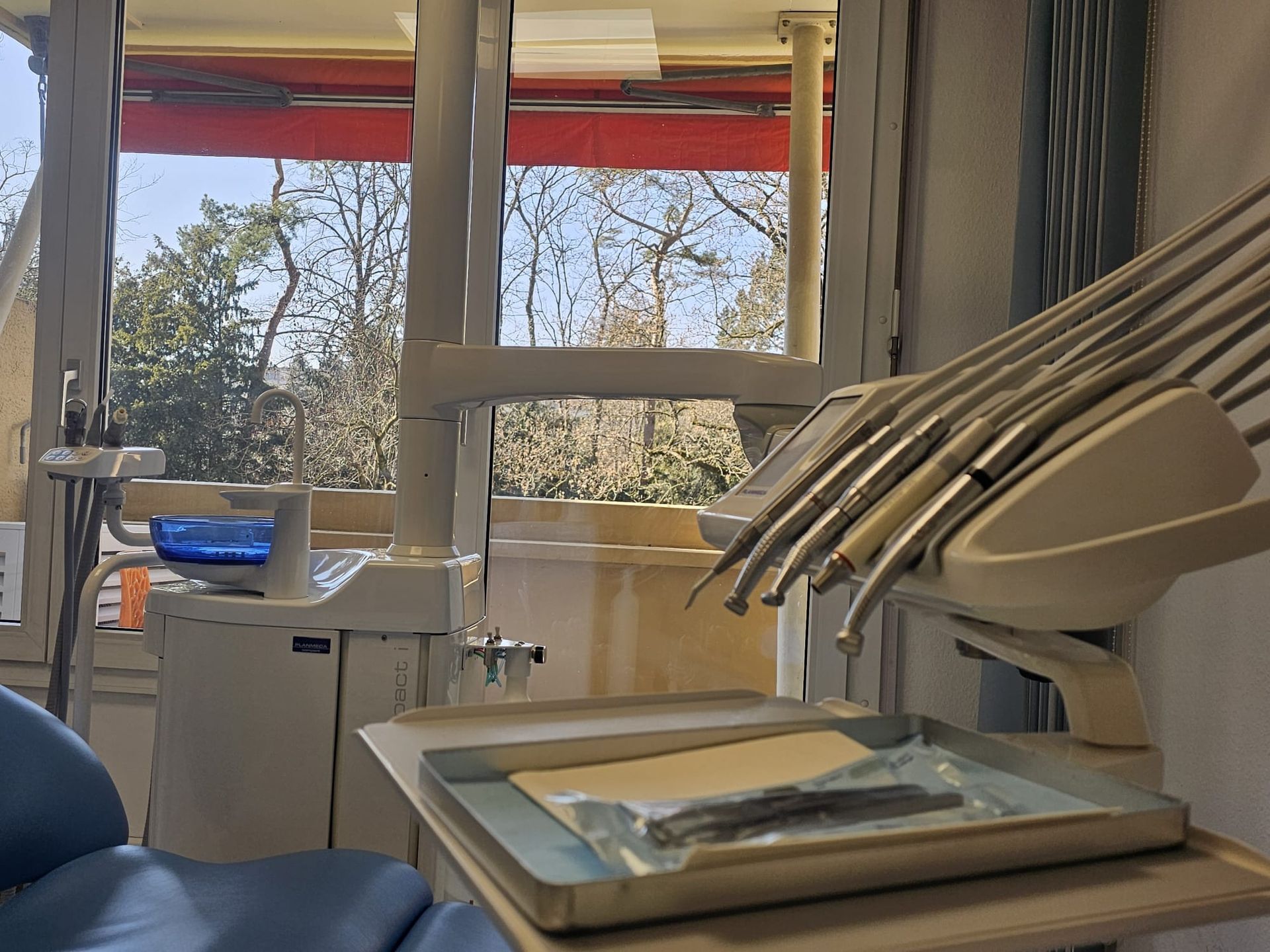 Un fauteuil dentaire avec un plateau d'instruments dentaires dessus