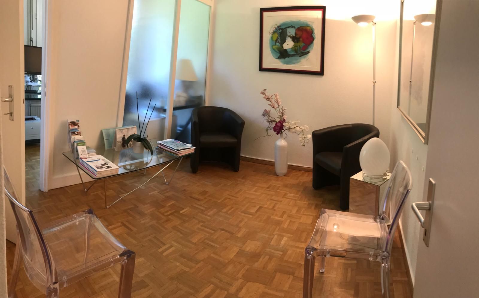 Une salle d'attente avec deux chaises et une table.