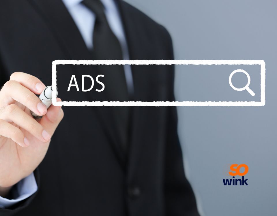Une personne en costume écrit « ADS » dans une barre de recherche, faisant allusion à la publicité en ligne.