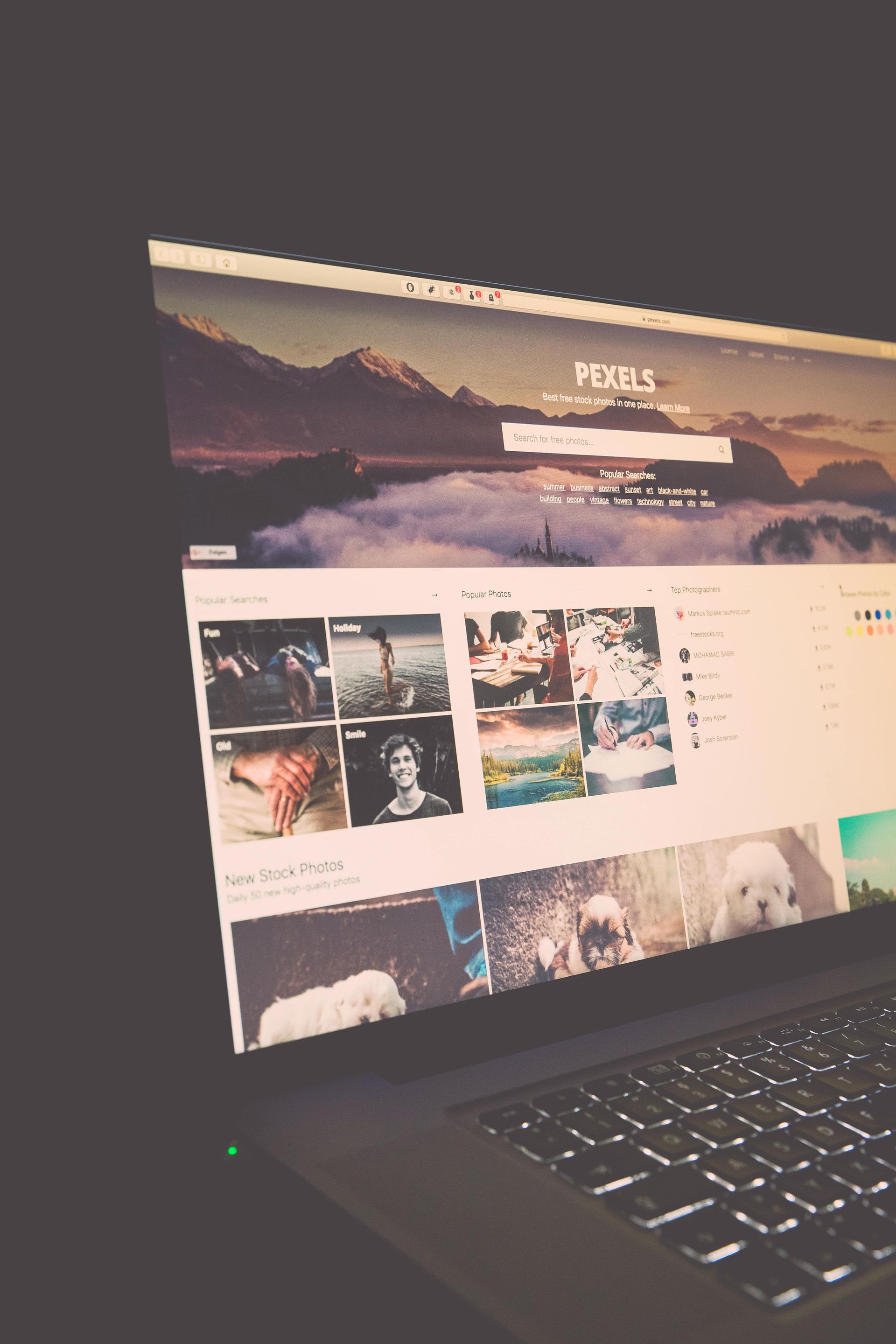 Un écran d'ordinateur portable affichant une page de profil avec une bannière représentant un paysage de montagne, dans une pièce faiblement éclairée.