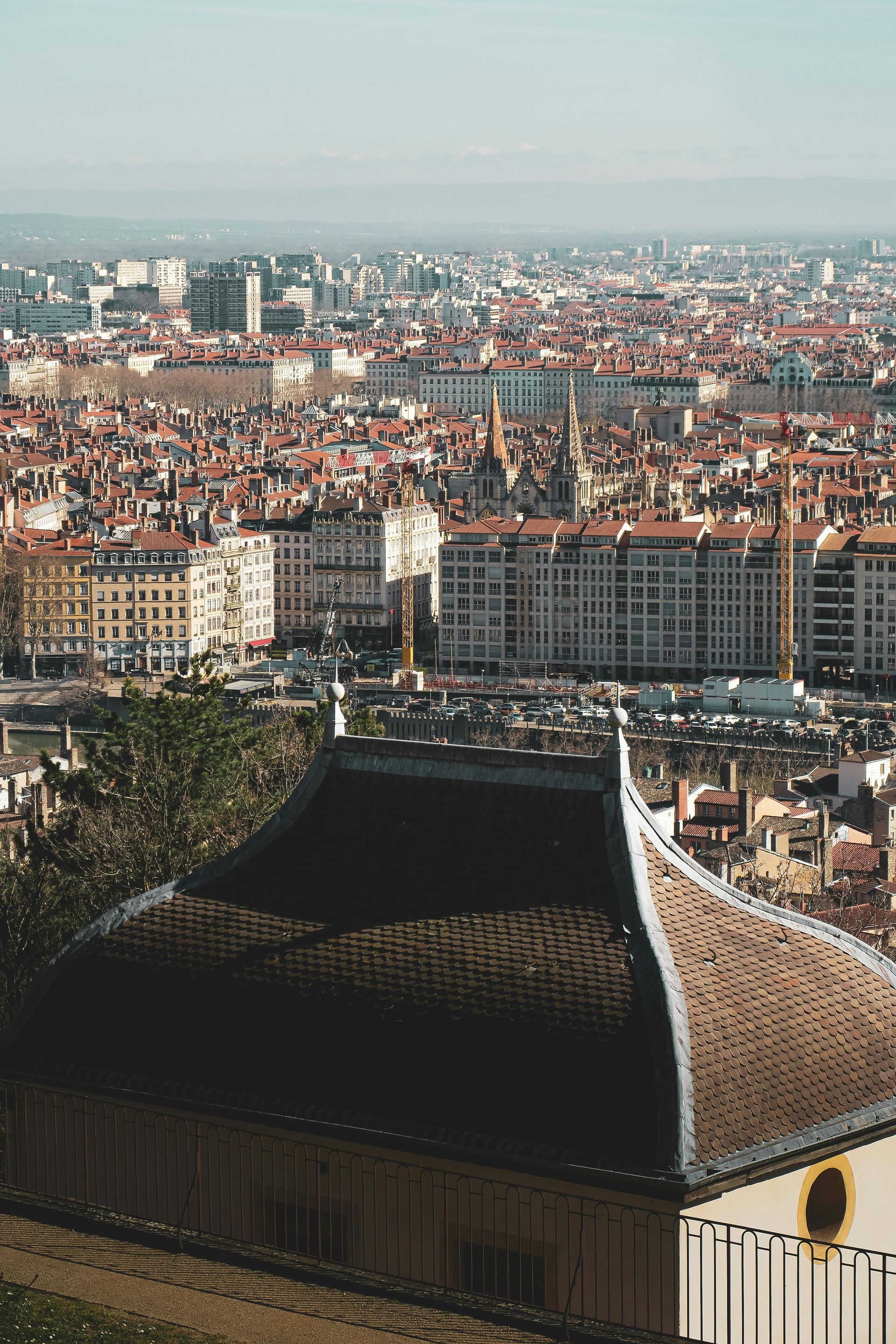 Vue aérienne des toits et des bâtiments de Lyon, en France, avec un toit de tuiles au premier plan.