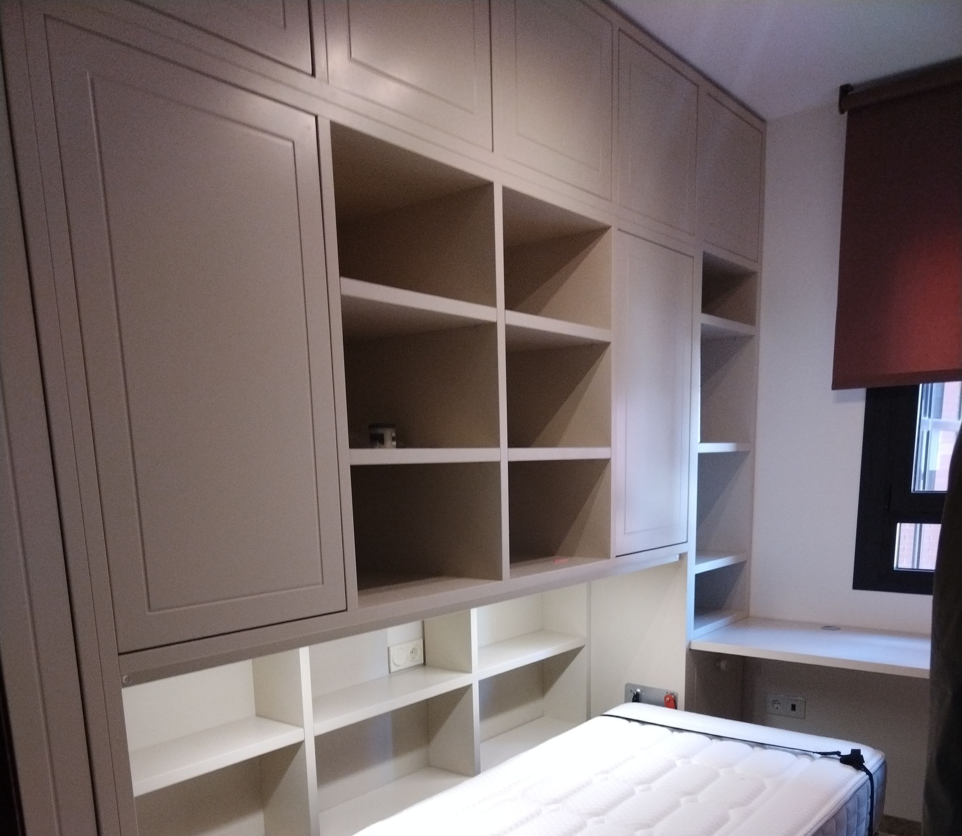 Un escritorio blanco en forma de L está ubicado en un rincón de una habitación.