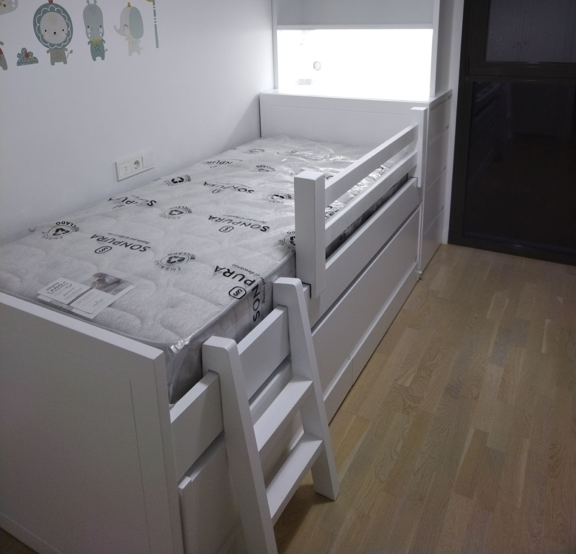 Un dormitorio con una cama y estantes y las palabras muebles dulces sueños en la pared.