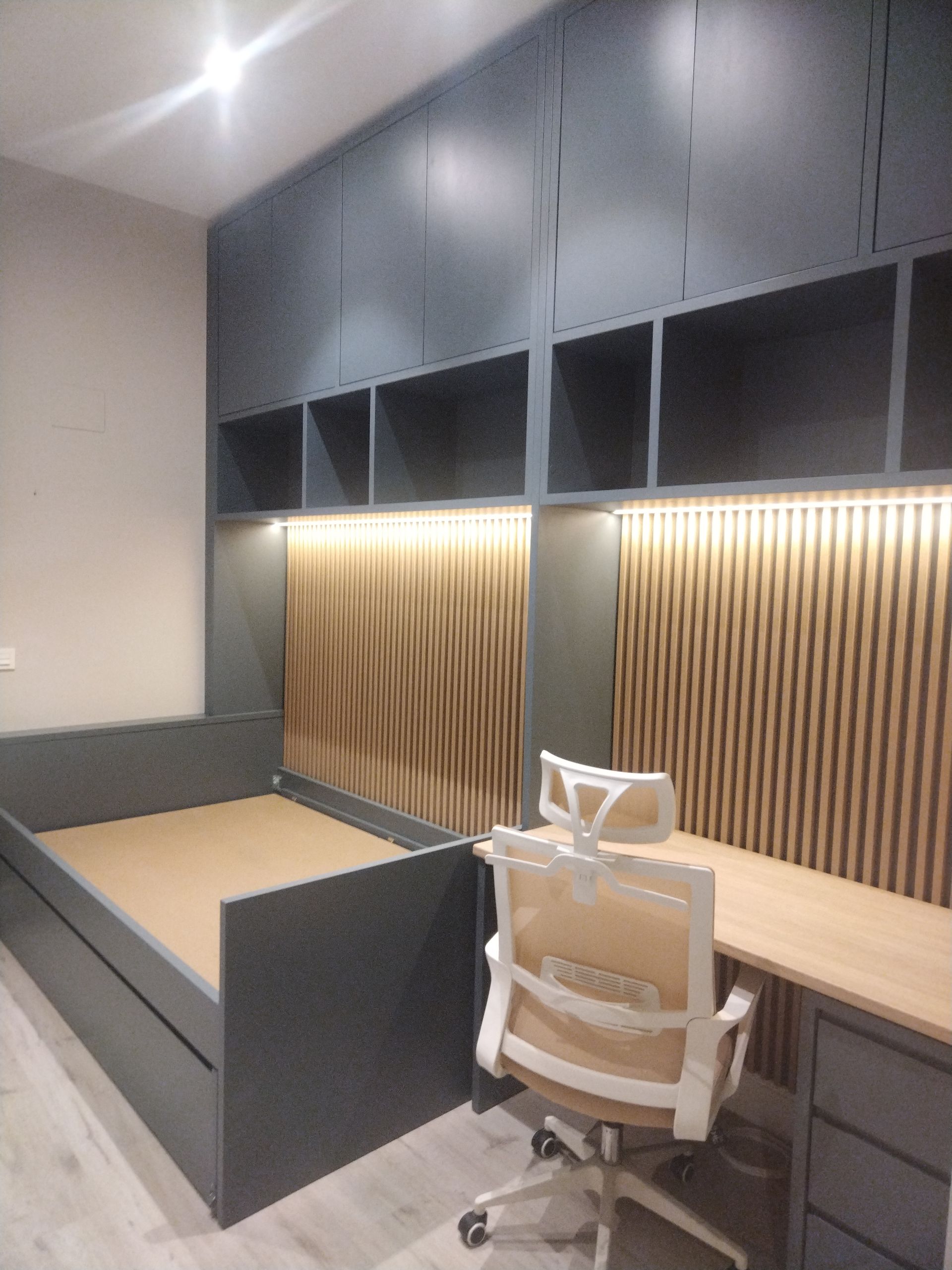 Una habitación con un escritorio y estantes tiene muebles dulces escrito en la pared.