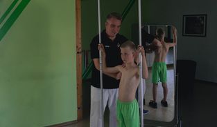 Krankengymnastik-Übung auf dem Gymnastikball mit Hanteln