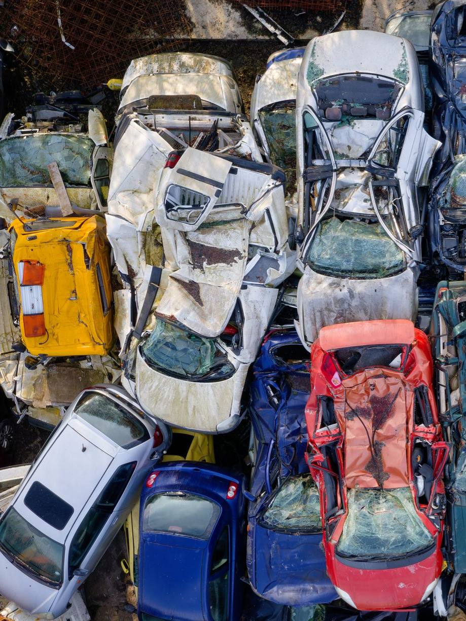 Vue aérienne d'une casse automobile très dense, présentant des véhicules écrasés et usés.