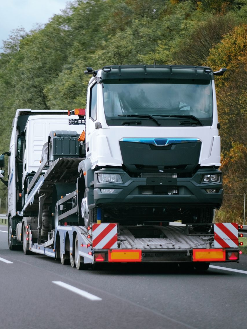 Un camion qui remorque un autre camion sur la route.