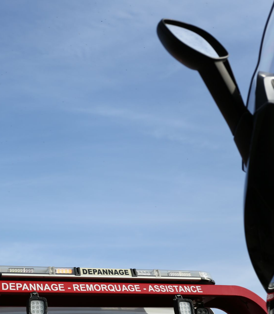 Camion de dépannage avec un scooter à côté.