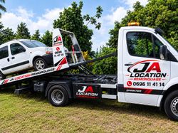 Une dépanneuse transporte une voiture sur une remorque.