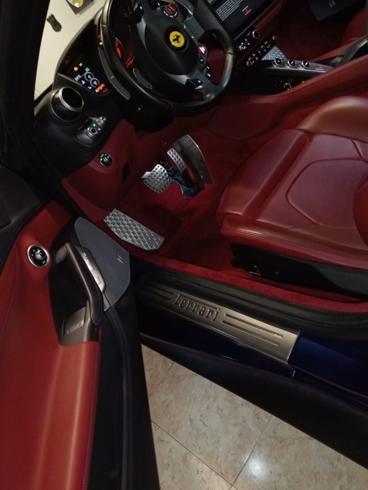 El interior de un coche Ferrari con la puerta abierta.
