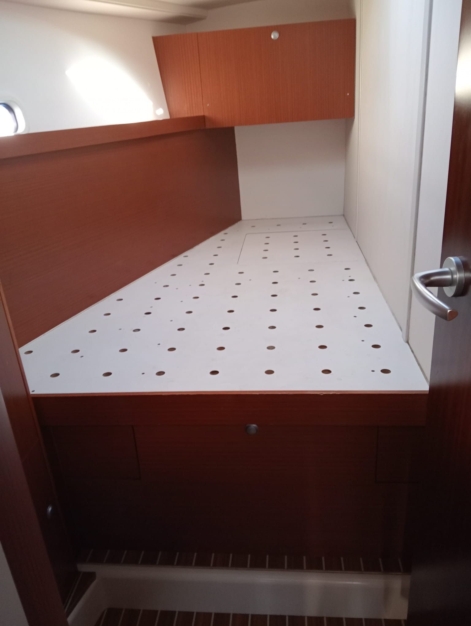 Una pequeña habitación con una cama y una puerta.