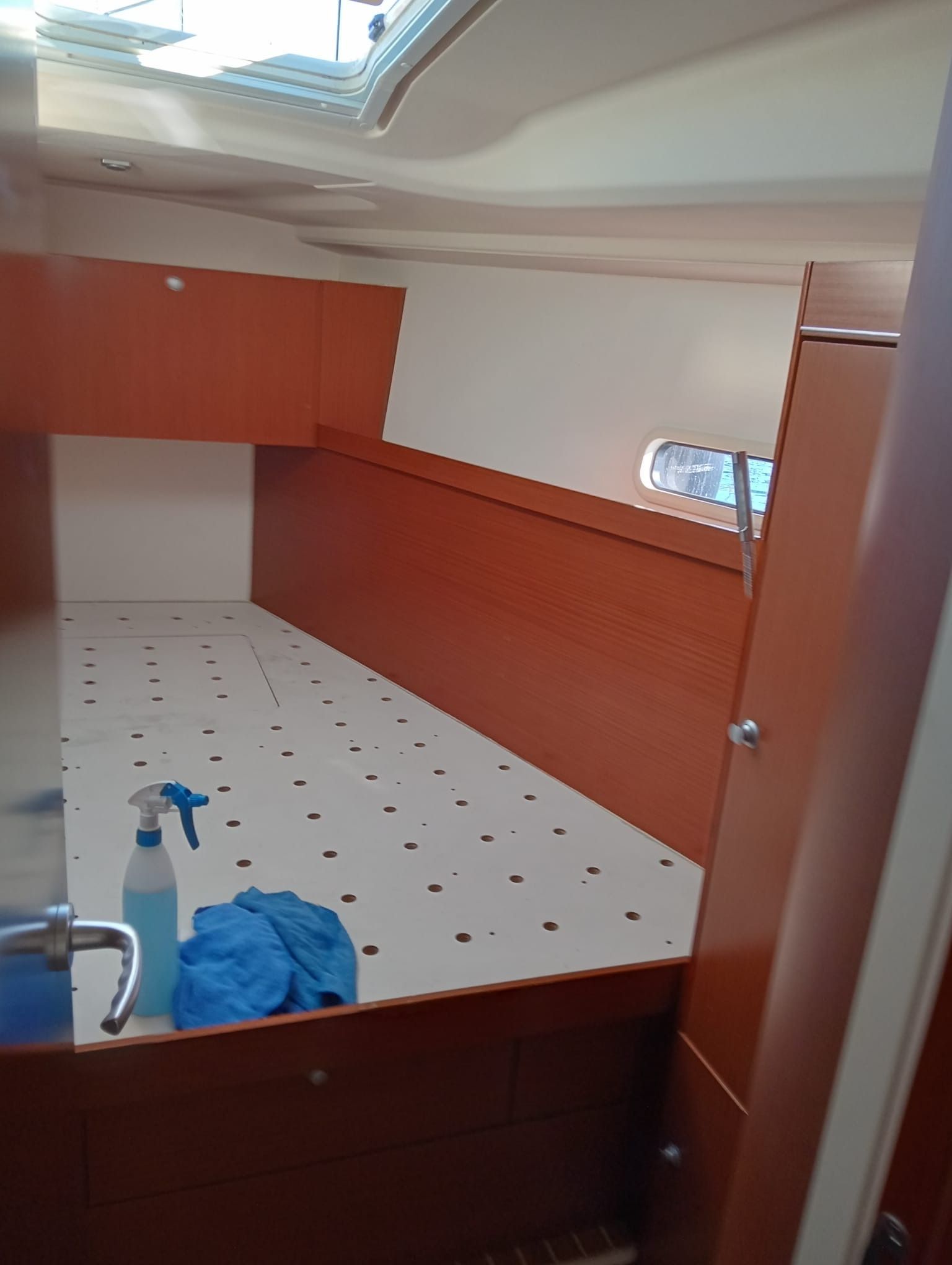 Una habitación con una cama y una botella de spray en el suelo.