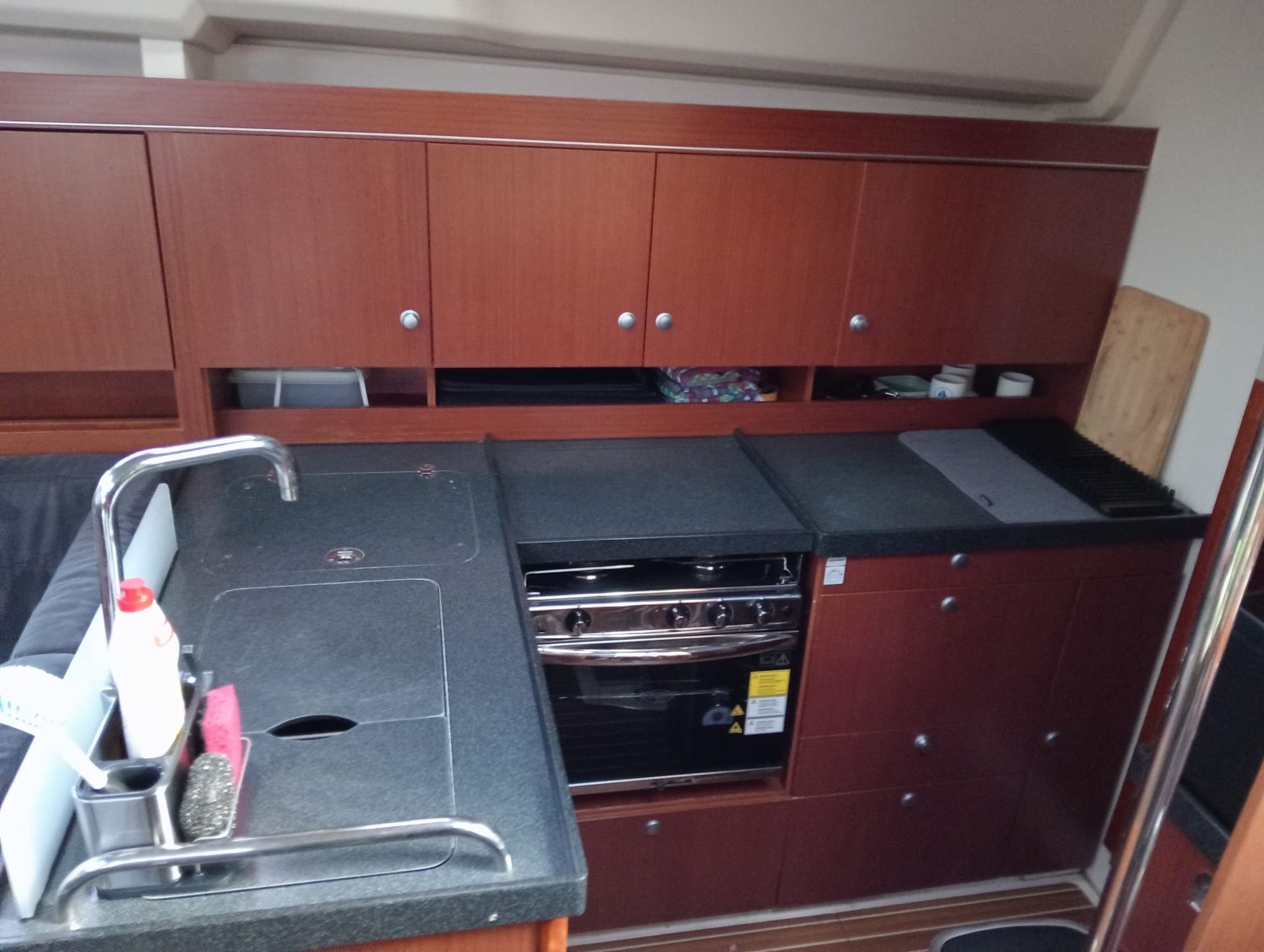 Una cocina con gabinetes de madera y una encimera negra.