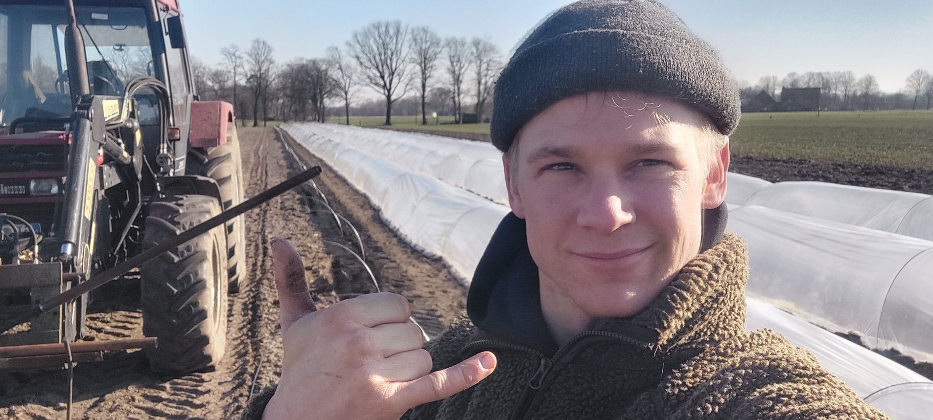 Mann neben einer Maschine auf einem Feld