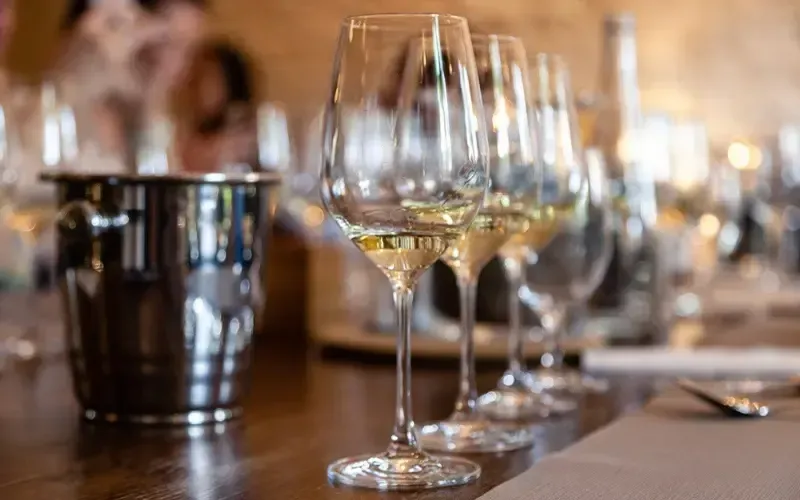 Des verres à vin posés sur une table de restaurant, à côté d’un seau à glace en métal