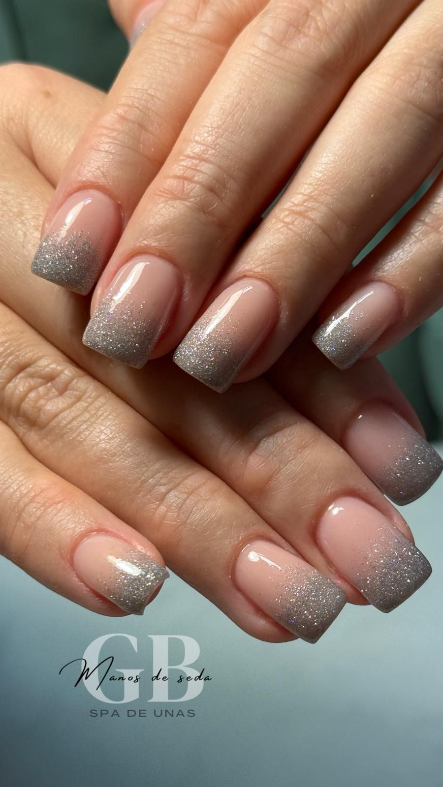 Uñas cuadradas con puntas brillantes, base rosa claro.