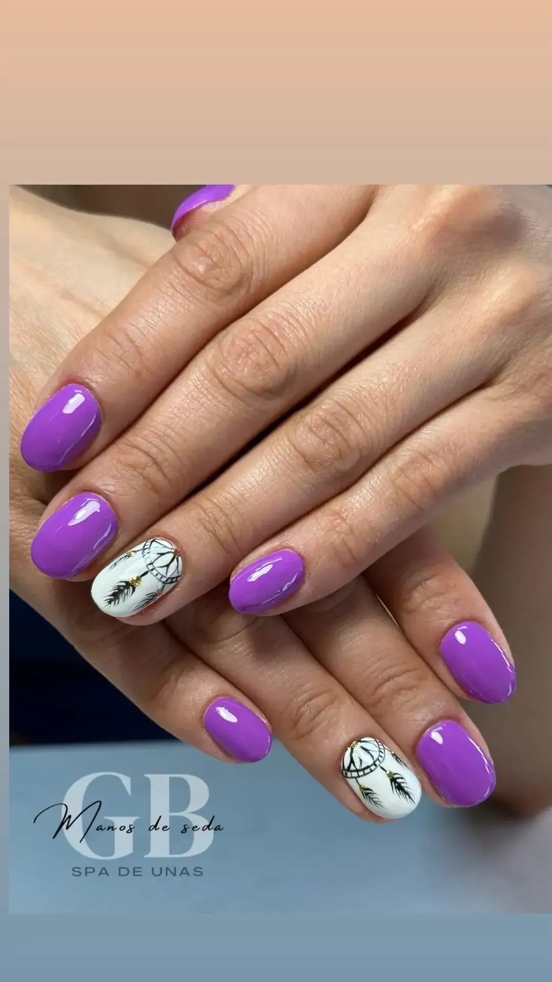 Manos con uñas ovaladas moradas, una uña decorada con un diseño de mármol blanco.