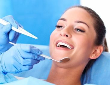 Una mujer está siendo examinada por un dentista.