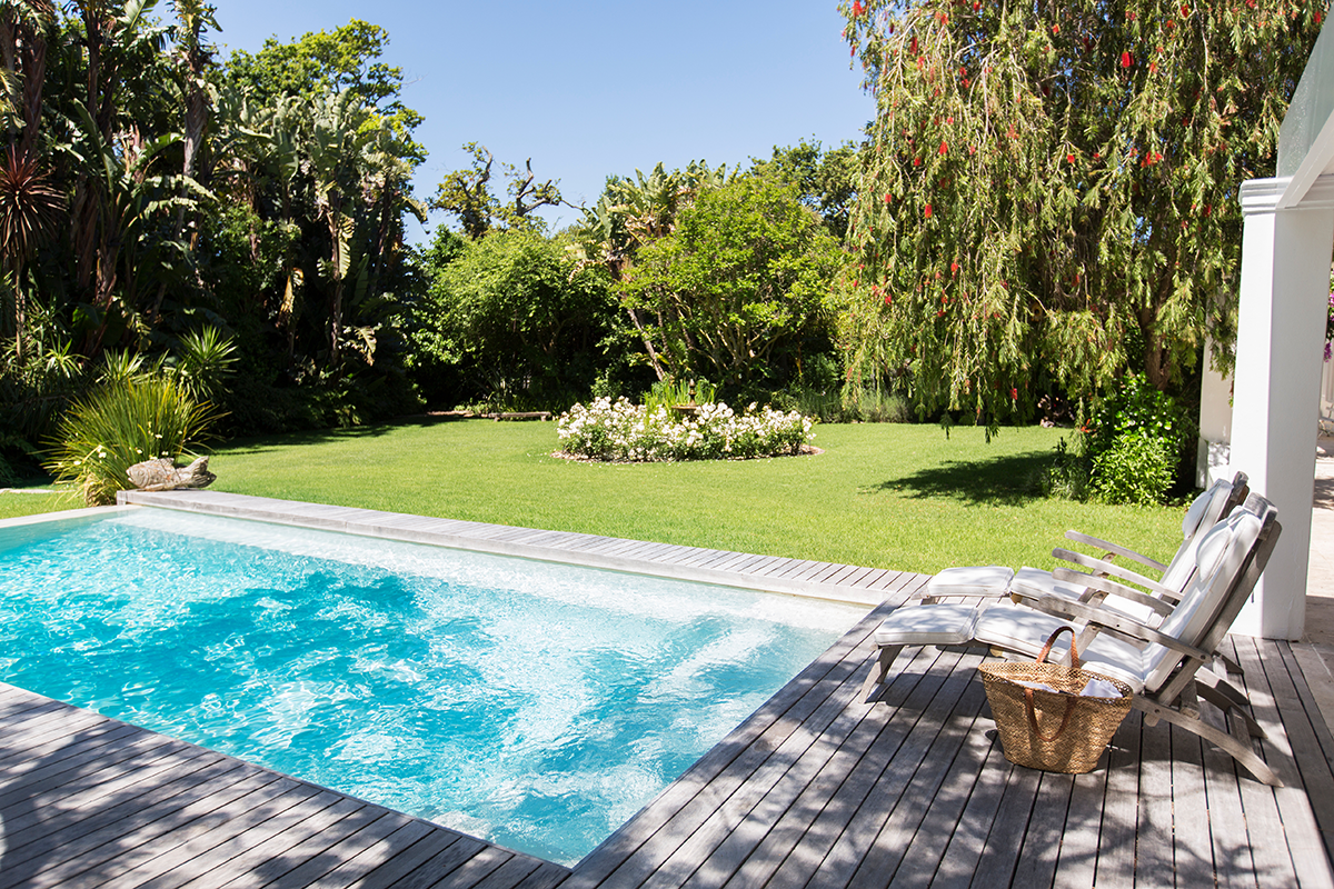Piscine dans un jardin avec des transats