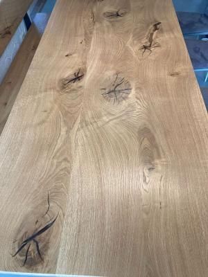 Eine Nahaufnahme eines Holztisches mit einer Bank daneben.