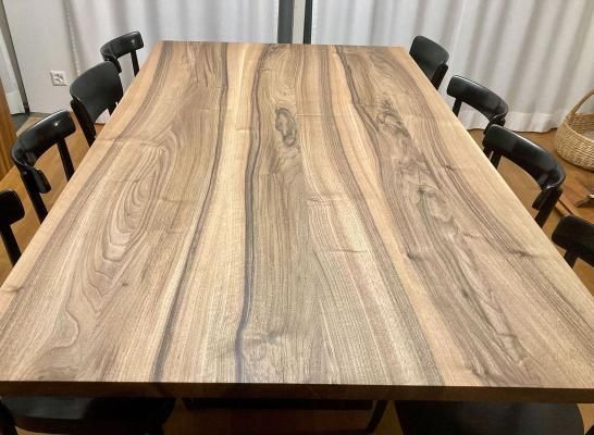 Ein Holztisch mit Stühlen darum herum in einem Raum.