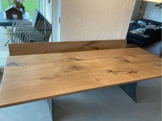 Ein Holztisch in einem Wohnzimmer neben einer Couch