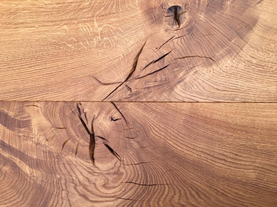 Eine Nahaufnahme eines Holzstücks mit einem Loch darin, das mit Giessharz aufgefüllt wurde.