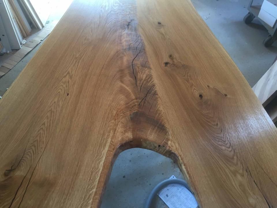 Eine Nahaufnahme eines Holztisches mit einem Loch das mit Giesharz aufgefüllt wurde