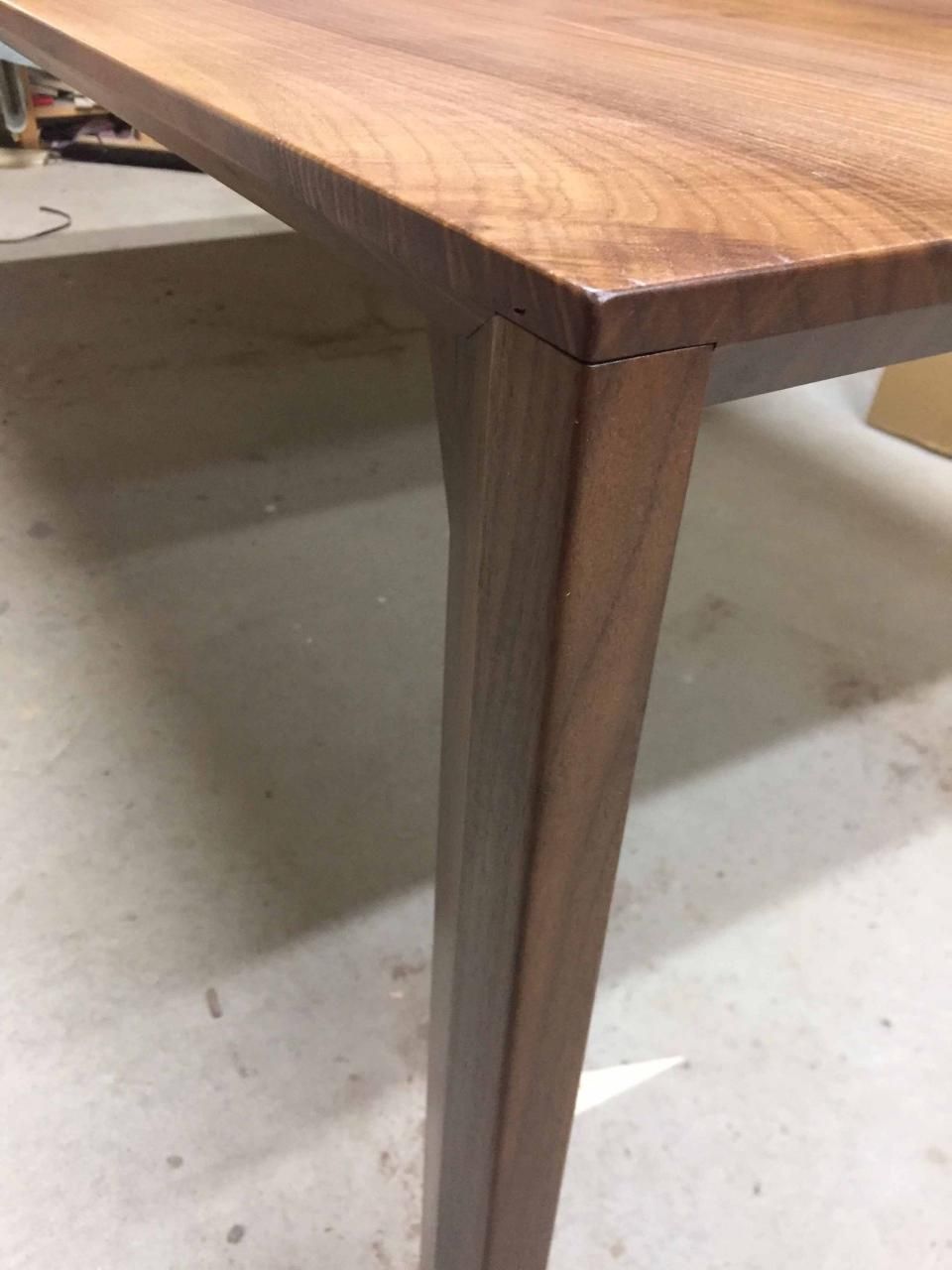 Ein Holztisch steht auf einem Betonboden.