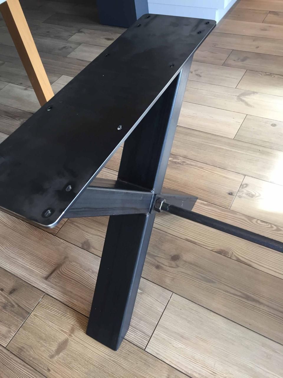 Ein schwarzer Metallrahmen steht auf einem Holzboden.