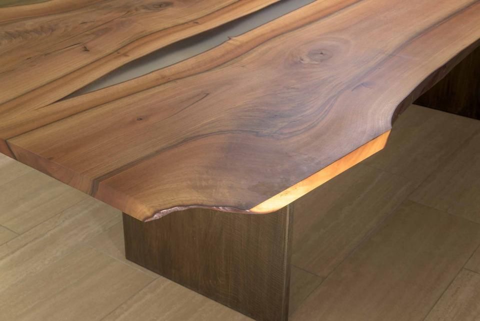 Eine Nahaufnahme eines Holztisches mit einer Lampe darauf.