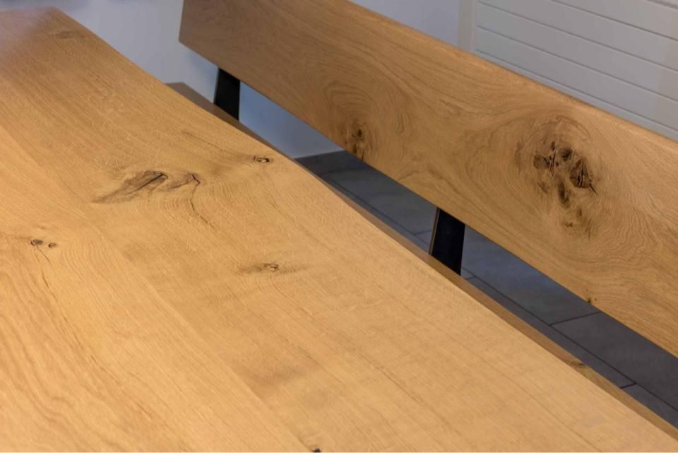 Neben einem Holztisch steht eine Holzbank.