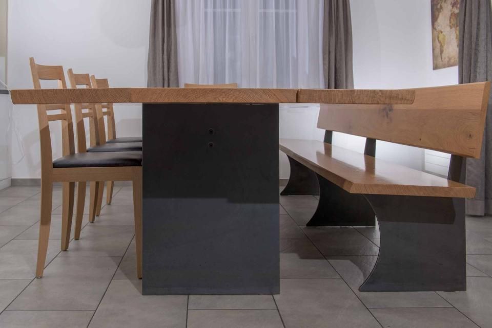 Ein Holztisch mit einer Bank und Stühlen in einem Esszimmer.