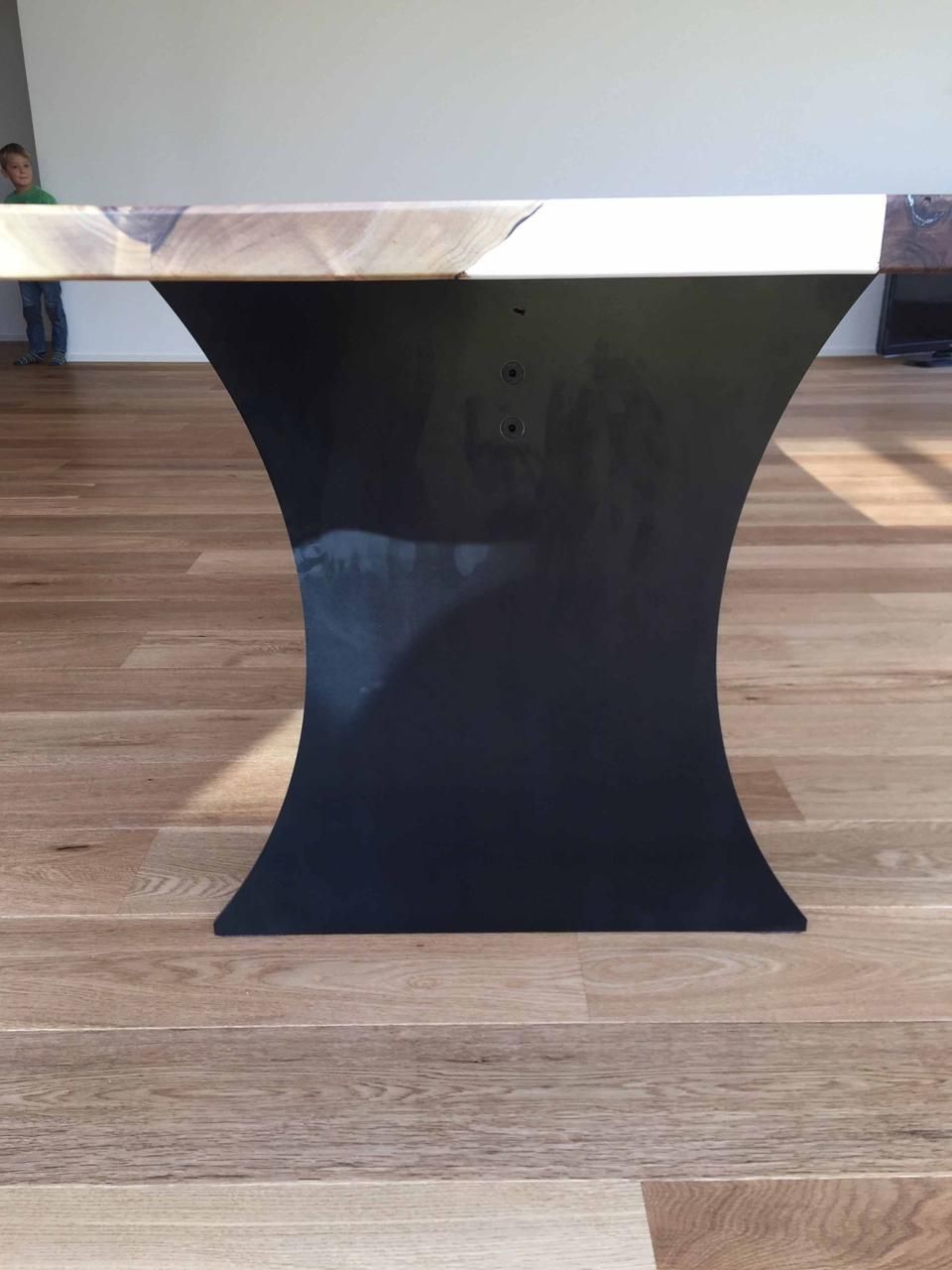 Ein Holztisch mit schwarzem Metallgestell auf einem Holzboden