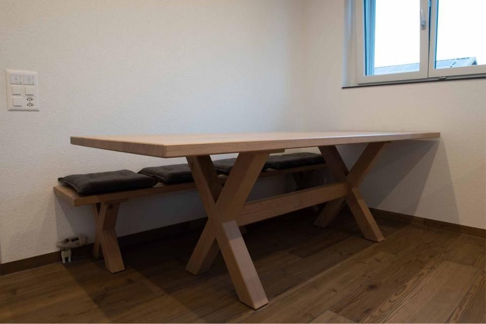 Ein Holztisch und eine Bank in einem Raum mit einem Fenster.