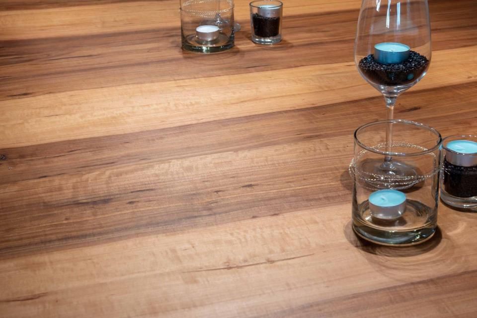 Ein Holztisch mit Kerzen und Weingläsern darauf.