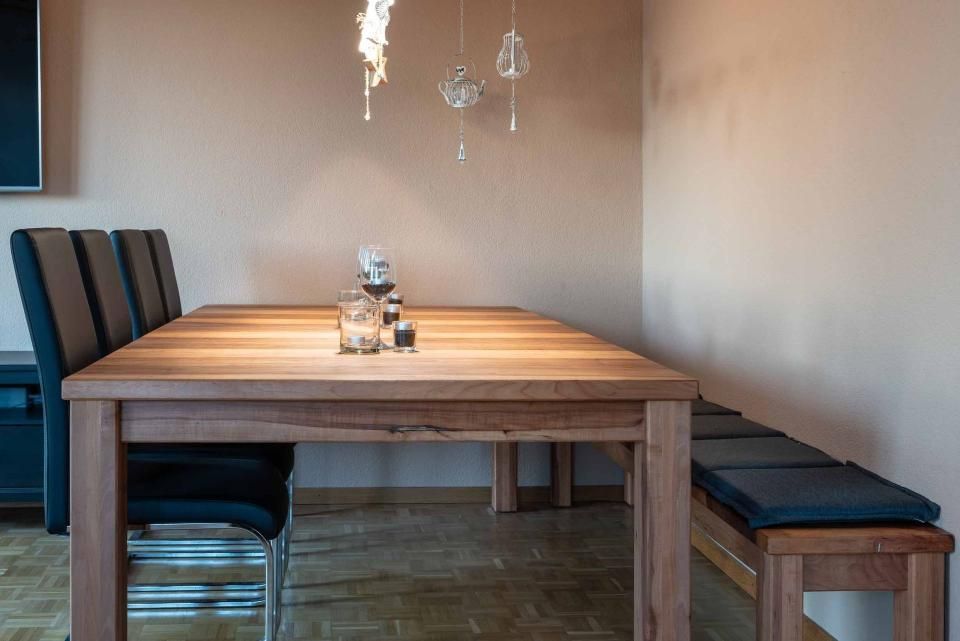 Ein Esszimmer mit einem langen Holztisch und Stühlen