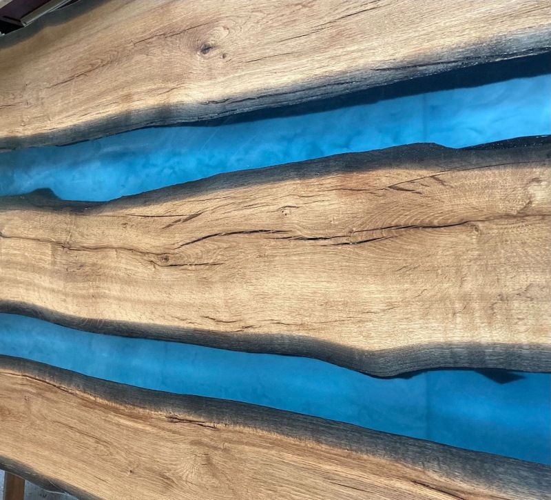 Eine Nahaufnahme eines Stücks Holz mit einem blauen Fluss darin.