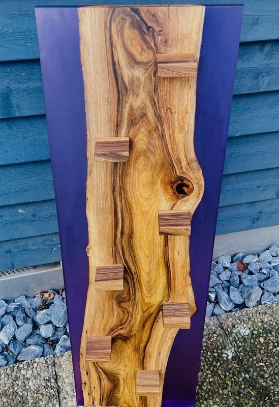 Ein Stück Holz liegt auf einer violetten Oberfläche.