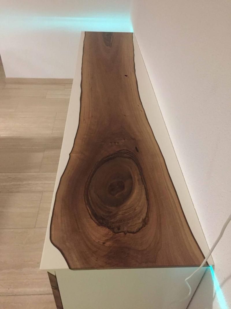 Ein Stück Holz liegt auf einer weißen Oberfläche.