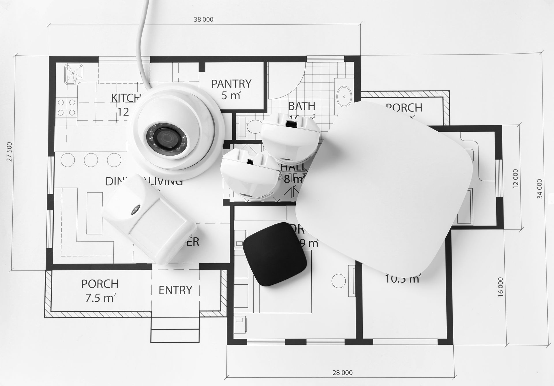 Un plan de maison avec du matériel de surveillance posé dessus
