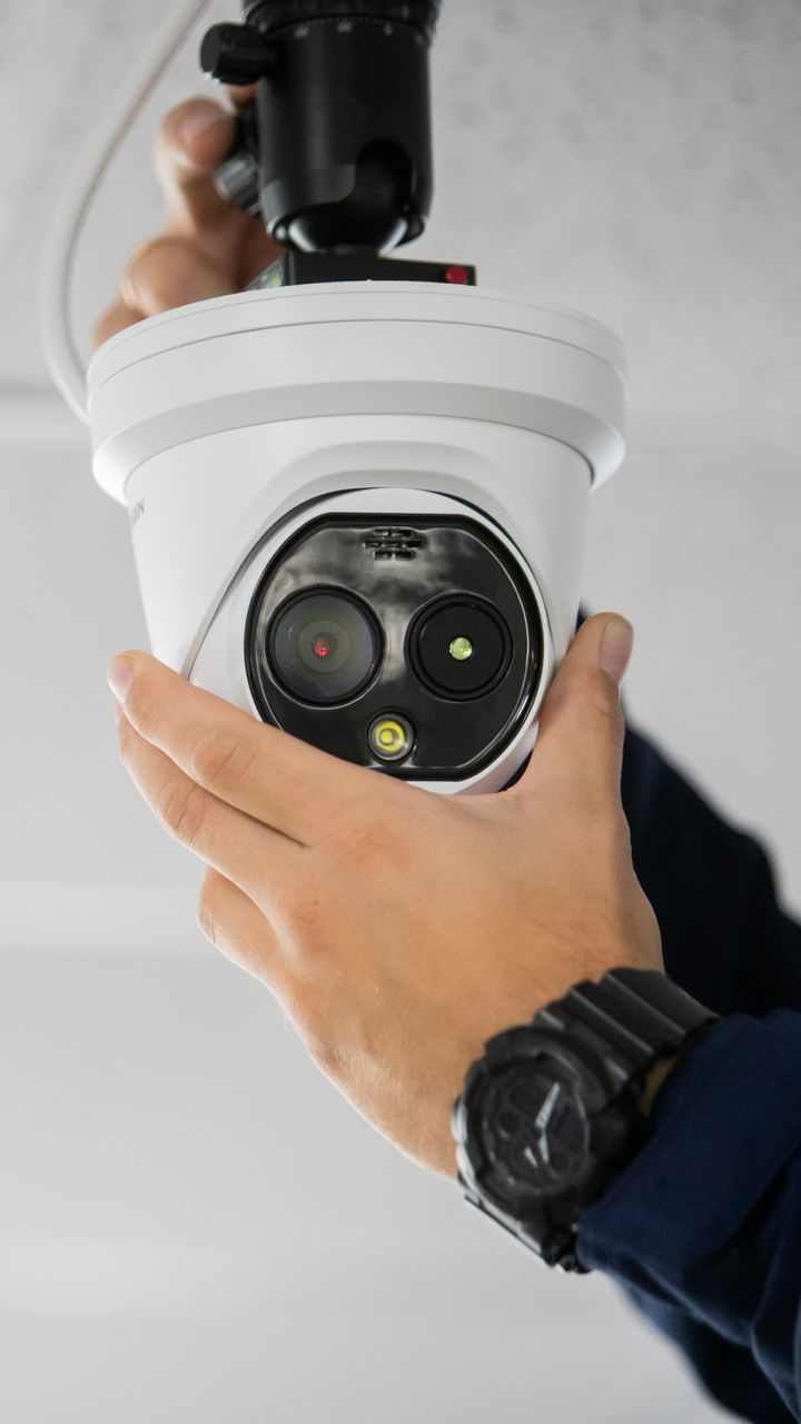 Un technicien posant une caméra au plafond
